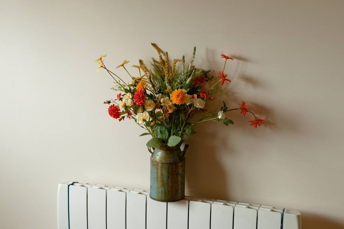 storage display silk plant artificial flower arranged on a minimalist floating shelf with woven baskets below