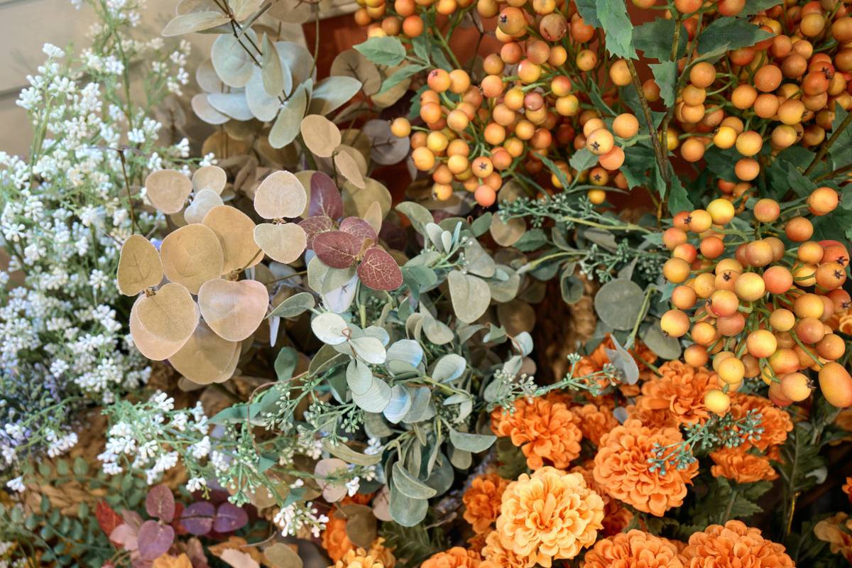A vintage-style collectible silk plant artificial flower home arrangement in a ceramic pot on a mid-century console table